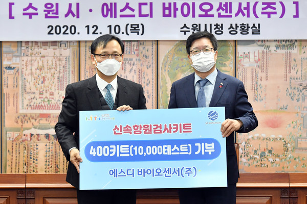 신속항원검사 키트 기증 후 염태영 시장(오른쪽)과 이효근 SD 바이오센서 대표가 함께하고 있다. [사진=수원시]