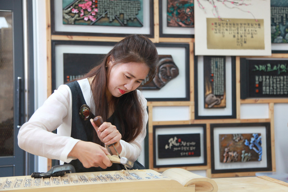 호산 김주연 전통서각 명인이 나무판에 글씨를 새겨넣고 있다.