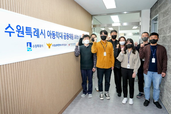 수원특례시 아동학대 공동대응센터에 소속된 실무자들이 센터 앞에서 파이팅을 외치며 기념촬영을 하고 있다.[사진=수원특례시]