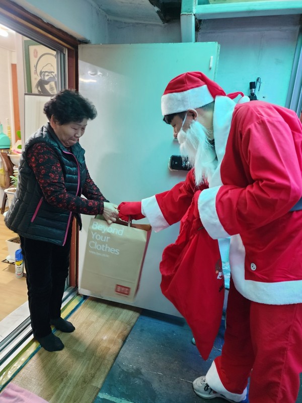 권선구보건소 직원들이 어르신에게 선물을 전달하고 있다.[사진=수원특례시]