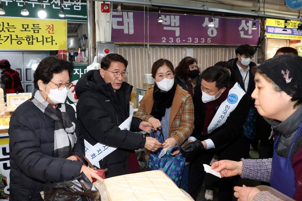 김기정 의장이 물건을 구매하며 상인들의 애로사항을 경청하고 있다.[사진=수원특례시의회]