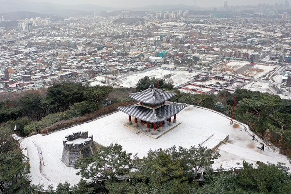 눈이 쌓인 서장대와 서장대에서 볼 수 있는 수원 구도심의 설경.[사진=수원특례시]
