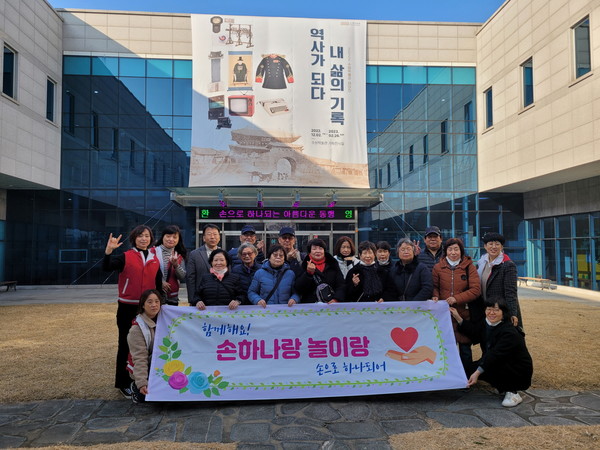 손으로 하나 되어 회원들과 농아인들이 수원박물관 앞에서 기념촬영을 하고 있다.[사진=수원특례시]