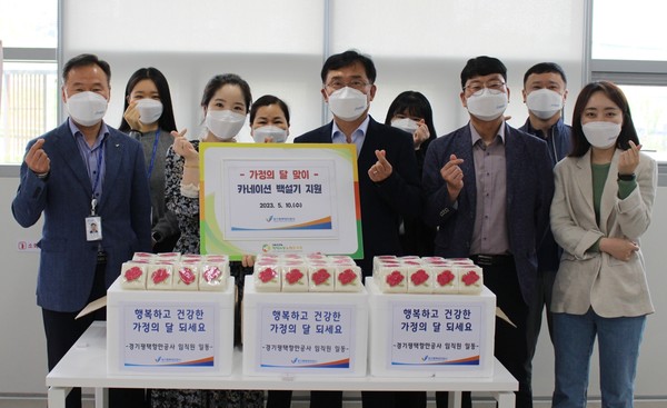 경기평택항만공사가 평택서부노인복지관에 카네이션 백설기를 전달한 후 단체사진 촬영을 하고 있다.[사진=경기평택항만공사]