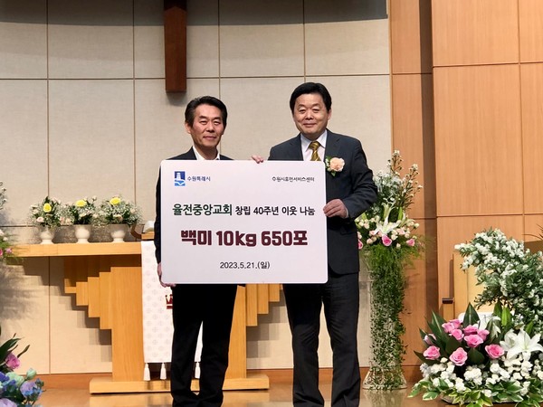 신준호 율전중앙교회 담임목사(오른쪽)과 최승래 수원시 복지여성국장이 전달식 후 기념촬영을 하고 있다.[사진=수원특례시]