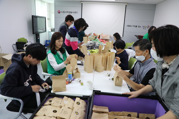 수원시여성리더회와 개인 봉사자들이 5일 수원시자원봉사센터에서 간식 2000개를 포장하고 있다. [사진=수원시]