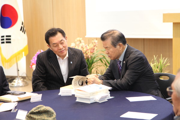 김훈동 작가(오른쪽)가 이재준 수원특례시장(왼쪽)에게 신간 ‘정조시대의 힘 정조의 사람들’의 내용에 대해 설명하고 있다 [사진=홍승혁 기자]