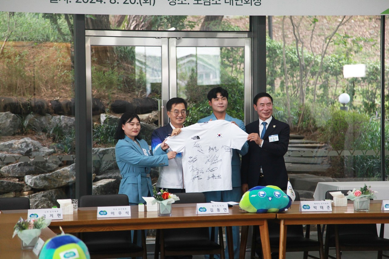 김동연 지사(왼쪽에서 두번째)가 이우석 양궁 금메달리스트(오른쪽에서 두번째), 금지현 공기소총 은메달리스트(왼쪽에서 첫번째) 등 국가대표 선수들이 사인한 유니폼을 이원성 체육회장(오른쪽에서 첫번째)에게 선물받아 기념사진을 촬영하고 있다.