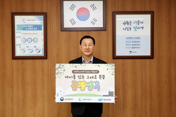 허정문 수원도시공사 사장이 18일 오전 더함파크 집무실에서 ‘아이를 있는 그대로 존중 긍정 양육’이 적인 피켓을 들고 아동학대예방 릴레이 캠페인’에 동참하고 있다. [사진=수원도시공사]