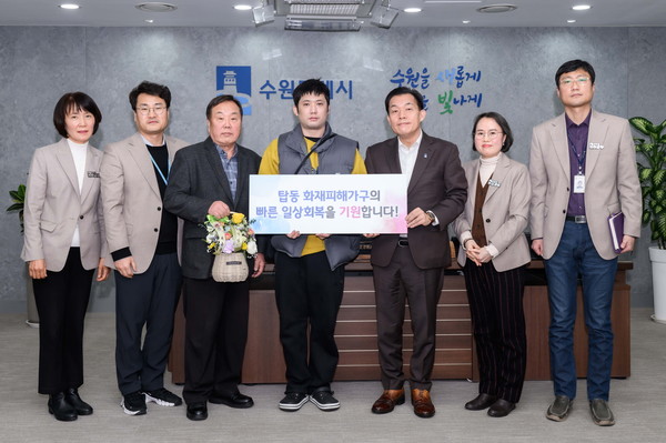 이재준 시장(오른쪽 세번째)과 김제영씨(가운데), 김씨의 큰아버지 김상근씨(왼쪽 세번째), 김씨에게 도움을 준 베테랑공무원들이 함께하고 있다. [사진=수원시]