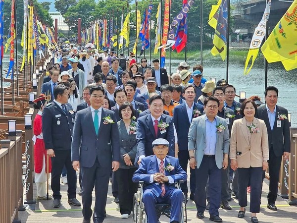 양평 세미원과 두물머리를 잇는 전통 배다리 개통식에서 전진선 양평군수(가운데)와 윤순옥 양평군의장(오른쪽에서 두번째)을 비롯한 내·외빈이 새로 개통한 배다리를 건너고 있다. [사진=허원무 기자]