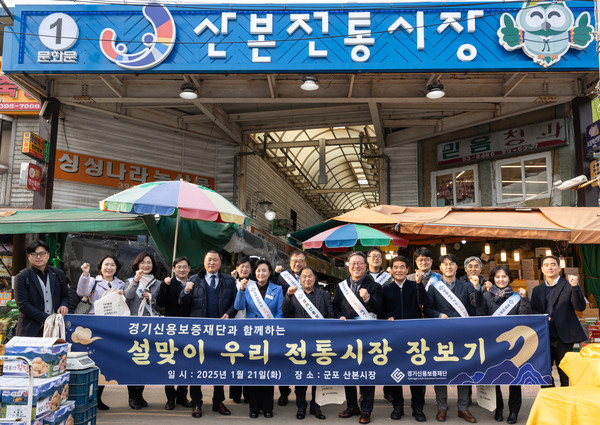 시석중 경기신용보증재단 이사장, 정윤경 경기도의회 부의장을 비롯한 관계자들이 21일 ‘전통시장 활성화를 위한 설맞이 장보기 행사’ 캠페인을 마치고 기념촬영을 하고 있다. [사진=경기신용보증재단]