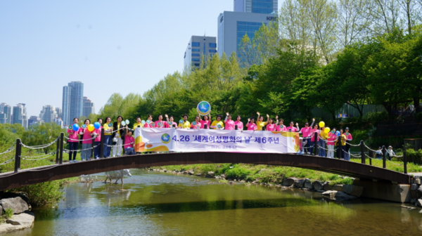 IWPG 관계자들이 양재천 다리에서 4.26 세계여성평화의 날을 기념하고 있다.