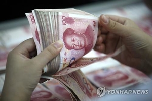 중국 은행 직원이 위안화 지폐를 세고 있다. [사진=EPA]