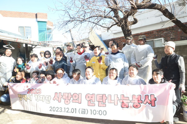 유승영 평택시의회 의장(아래줄 오른쪽 다섯번째)이 사랑의 연탄나눔봉사를 마치고 봉사자들과 함께 기념촬영을 하고 있다.